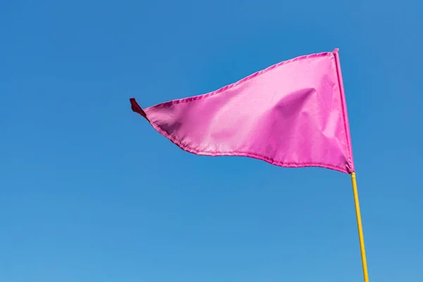 Розовый Флаг Размахивающий Ветру Против Чистого Голубого Неба — стоковое фото