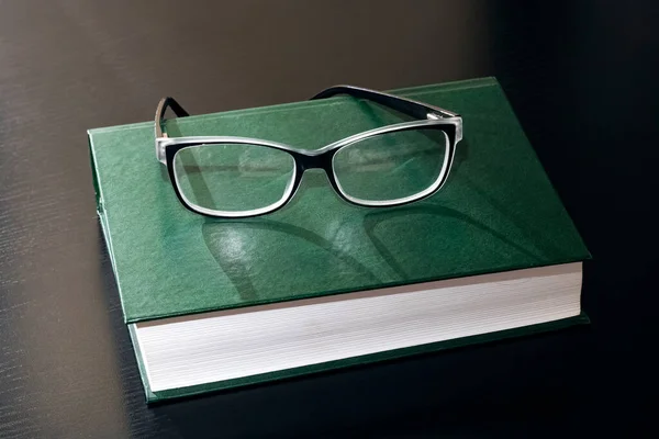 Zwarte Bril Een Boek Een Houten Tafel — Stockfoto