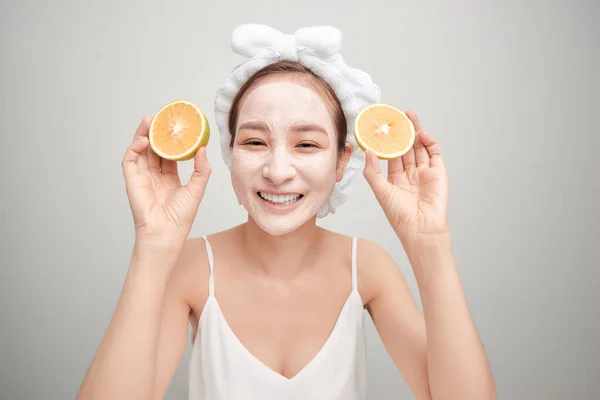Młody Azji Mając Biały Twarzy Gliny Maska Gospodarstwa Pomarańczowy Kawałek — Zdjęcie stockowe