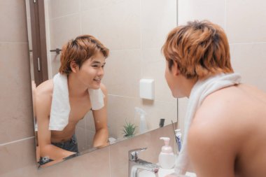 Yakışıklı adam banyoda yüz yıkama