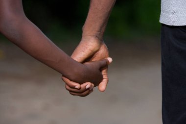 Baba ve oğul el ele tutuşup yolda yürüyorlar.