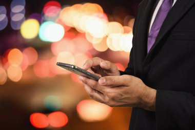İş adamı cep telefonu gece lambasını kullanıyor.