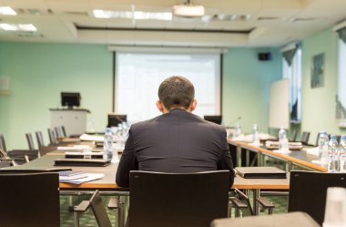 İş adamı iş konferansı için odada oturuyor