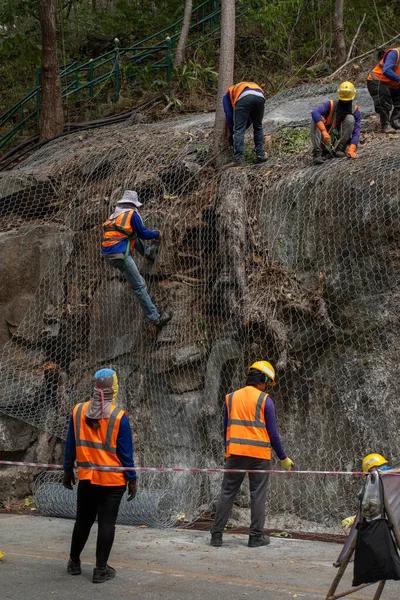 Nşaat Işçileri Yol Kenarındaki Büyük Kayaları Örtmek Için Ağı Kullanıyorlar — Stok fotoğraf