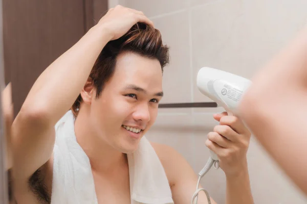 Young Man Blowing Hair Dryer While Looking Mirror — Stock Photo, Image