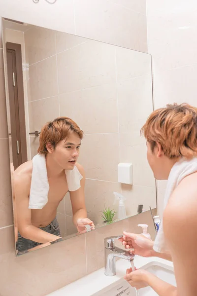 浴室洗面台で顔を洗う男 — ストック写真