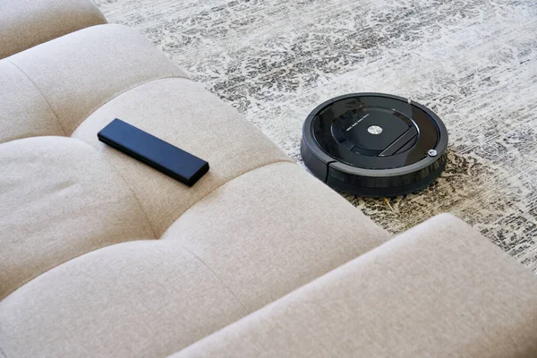 居心地の良い現代のリビングルームの床にロボット掃除機 — ストック写真