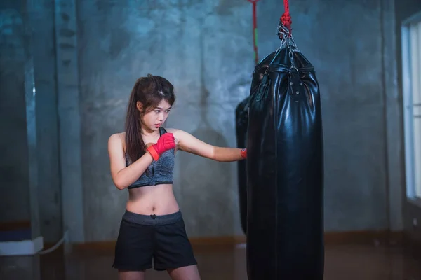 性感的亚洲女孩冲拳击袋 — 图库照片
