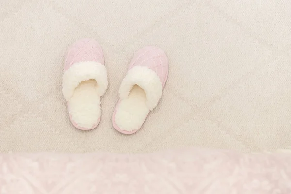 铺在地板地毯上的粉色舒适针织拖鞋 — 图库照片