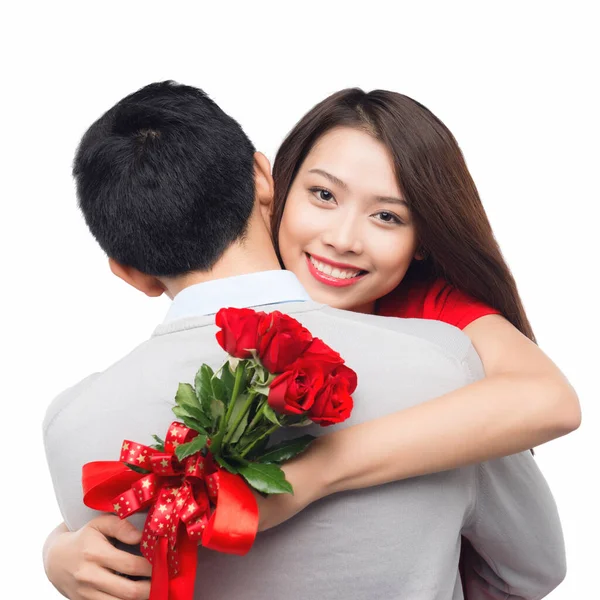 浪漫的时刻 一个年轻人把玫瑰送给他的女朋友 拥抱夫妻幸福的拥抱 在白种人的背景下谈恋爱时笑逐颜开 — 图库照片