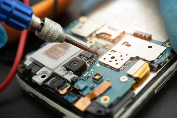 鉄をはんだ付けして携帯電話の内部を修理する技術者 集積回路 データ ハードウェア テクノロジーの概念は — ストック写真