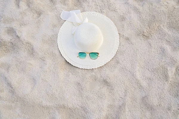 在晴朗的日子里 帽子和眼镜位于大海蓝色的沙滩上 — 图库照片