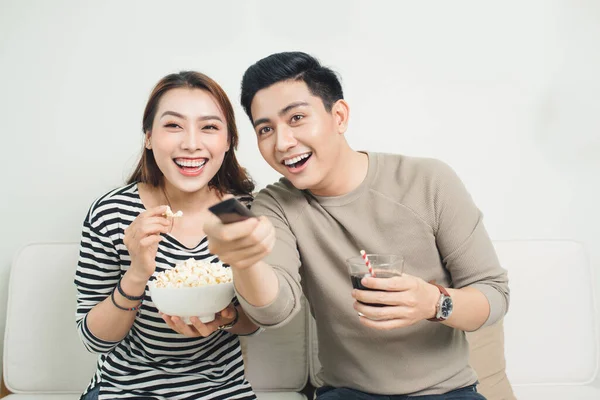 兴奋的年轻亚洲夫妇 边看电视边吃爆米花 — 图库照片
