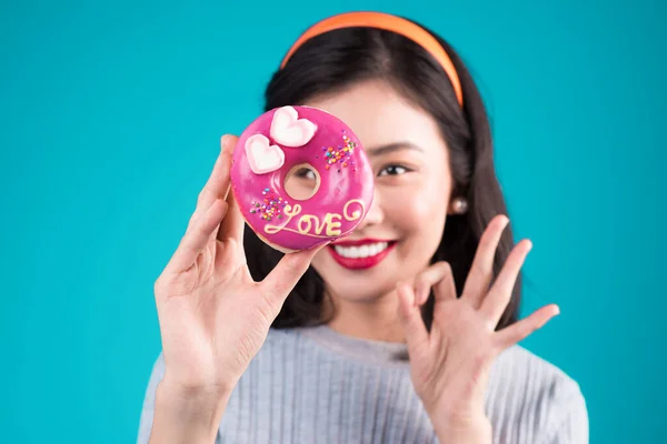 亚洲美女用粉红甜甜圈挡住她的眼睛 复古的快乐女人与糖果 甜点站在蓝色背景之上 — 图库照片