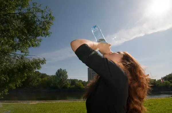 公園で水を飲む若い女性 — ストック写真