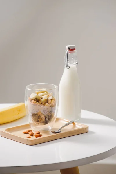 健康的な食事ができて栄養価の高い朝食 アーモンド チア種子 バナナとキウイ フルーツとベリーとグラノーラと近隣の牛乳瓶 — ストック写真