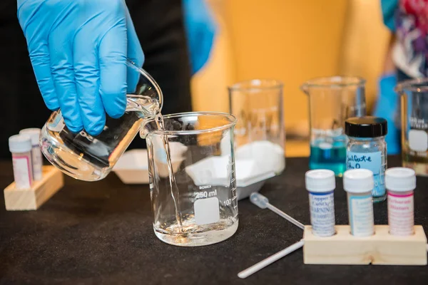 Rękawice Lateksowe Polewają Zlewkę Płynu Podczas Eksperymentu Naukowego Laboratorium Szkolnym — Zdjęcie stockowe