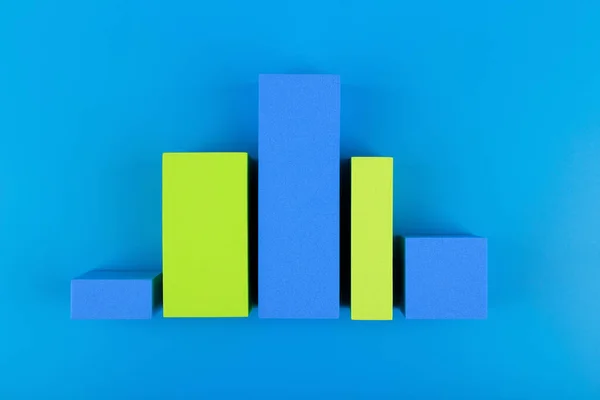 Business graph diagram or performance chart with blue and green bars with rise and fall dynamic against blue background