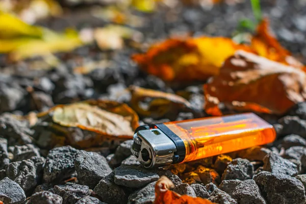 Orangefarbenes Feuerzeug Liegt Auf Steinen Zwischen Abgefallenen Blättern — Stockfoto