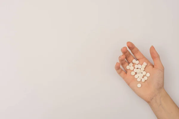 handful of white pills in the palm of your hand. copy space