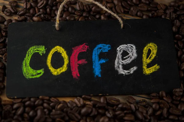 カラフルなアルファベットで書かれた碑文のコーヒー豆とボードをヒープ コーヒーブレイク朝目を覚ますというコンセプト — ストック写真