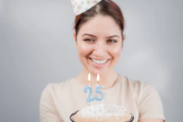 幸せな女性は願い事をし 25歳の誕生日ケーキにろうそくを吹き消します 誕生日を祝う女の子 — ストック写真
