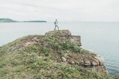 Yüksek kıyı şeridinde yürüyen kaşif kadın.