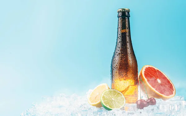 氷の上に閉じ込められた茶色のガラスビール 果物が近くにある フルーツクラフトビールやサイダーの概念 — ストック写真