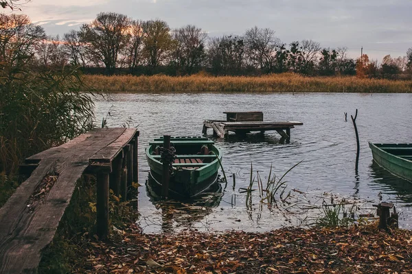 川の岸の近くのボートは 水と黄金の秋の夕日の時間でいっぱい — ストック写真