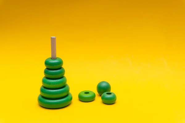 Pyramida Postava Zelených Dětí Dřevěné Hračky Kroužky Žlutém Pozadí — Stock fotografie