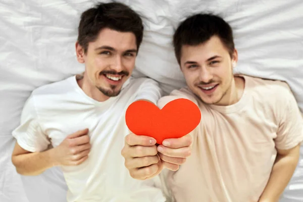 ゲイカップル保持赤い紙の心と笑顔 — ストック写真