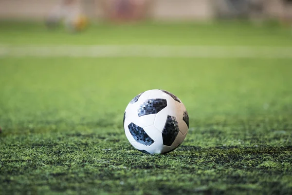 サッカー場の芝生の上で伝統的なサッカーボール — ストック写真