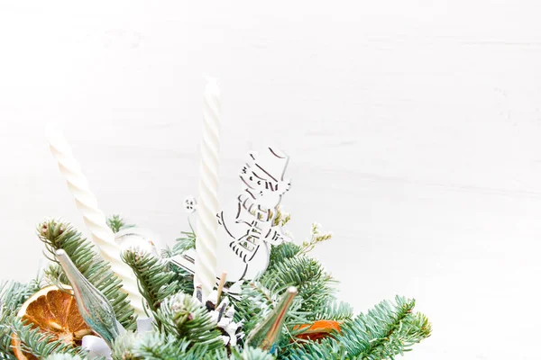 一束冷杉枝条 由雪人 圣诞玩具 干橙子和白蜡烛装饰而成 圣诞花束 复制处 浅色背景 — 图库照片