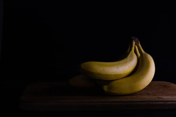 Bananas Uma Tábua Madeira Fundo Escuro — Fotografia de Stock