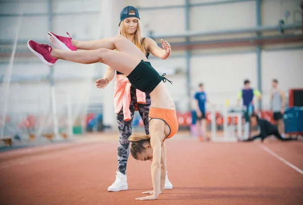 Две Молодые Спортсменки Занимаются Спортом Женщина Стоит Руках Балансирует Другая — стоковое фото