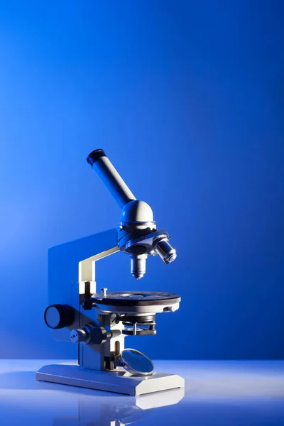 Microscope on blue studio background