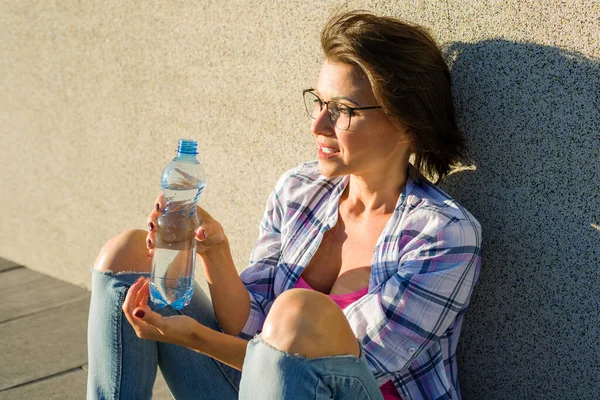成人の健康な女性はボトルから水を飲む — ストック写真
