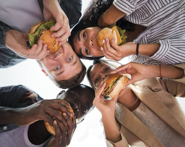 下から見てハンバーガーを食べる友達 — ストック写真