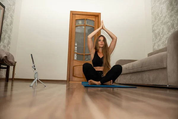 Uzun Saçlı Genç Bir Kadın Spor Giyim Eğitmeni Evde Yoga — Stok fotoğraf
