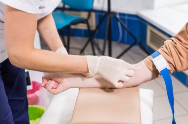 Doktorun yakın çekimi analizden kan alır..