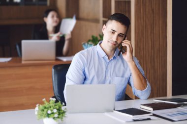 Erkek pazarlama müdürü, kâr potansiyelini artırmak için risk sermayesi şirketiyle konuşmak için telefonu kullanıyor..