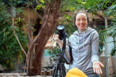 Elinde fotoğraf makinesi olan mutlu bir bayan.