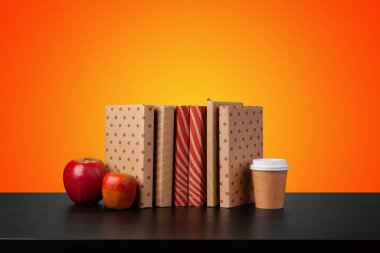 Renkli arka plana karşı bir masanın üzerinde kitap yığını olan eğitim kavramı.