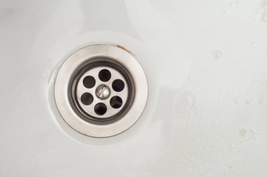 Beyaz seramik lavabodaki suyu boşaltmak için şebeke