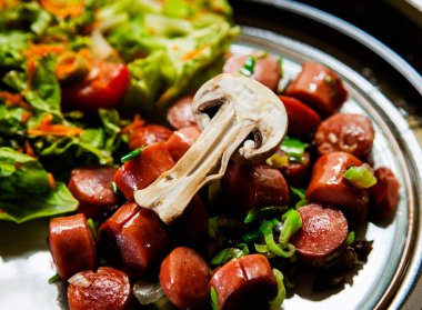 Arka planda mantarlı lezzetli sosislerden yakın çekim.