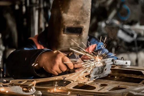 戴防护面罩的焊工正在工厂车间进行汽车门的焊接 点火和修理工作 — 图库照片