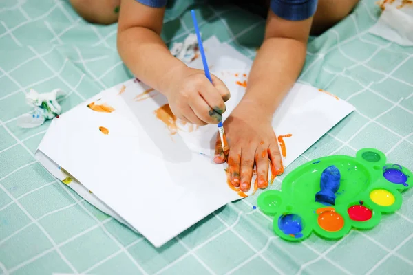 Focus on their hands on paper. Children use brushes to draw their hands on paper to build their imagination and enhance their cognitive skills