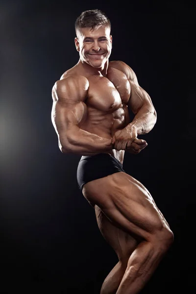 Forte Musculoso Atleta Atleta Homem Posando Bombeando Músculos Fundo Preto — Fotografia de Stock