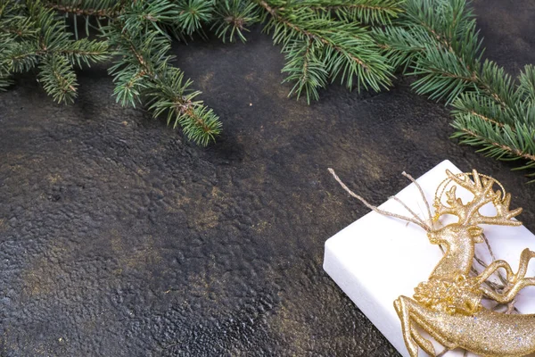 モミの枝 金リボン 文字のための場所で金エンボス加工の背景と黒のクラフト紙のギフトボックスのクリスマス構成 — ストック写真