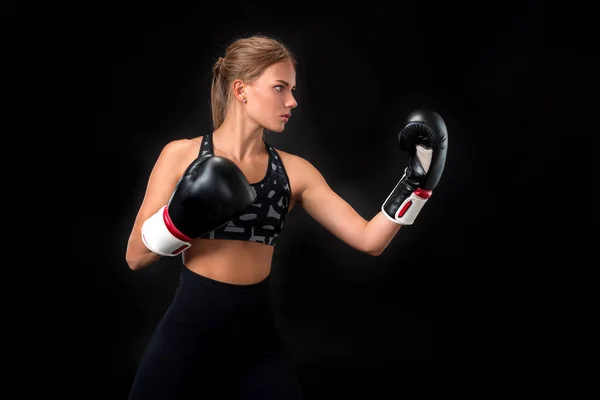 美丽的女运动员在拳击手套 在演播室在黑背景 — 图库照片